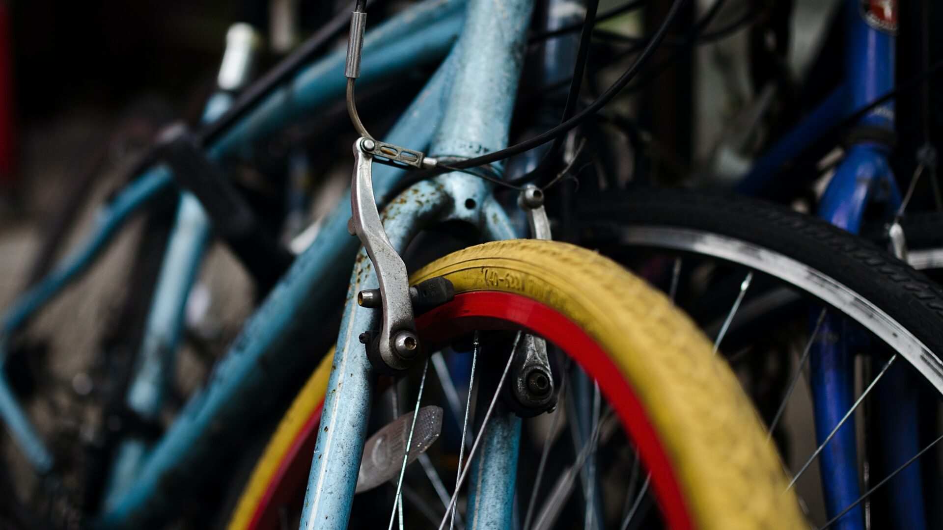 Mehrere, ältere Fahrräder lehnen aneinander.